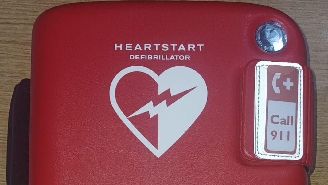 Ilustración de un desfibrilador automático externo (DEA) sobre un fondo neutro.