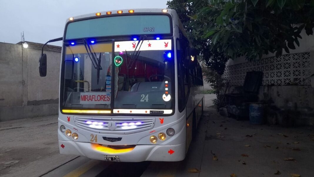 Grupo de estudiantes esperando en una parada de colectivo al anochecer en Catamarca