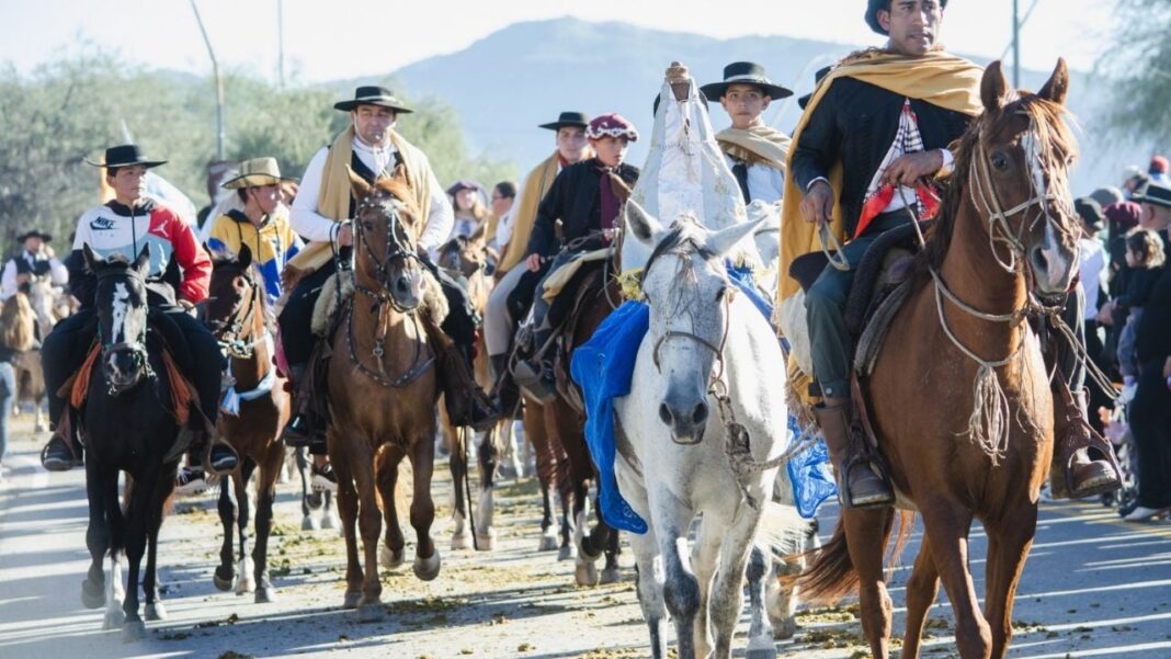 Jinetes y carruajes durante la cabalgata en honor a la Virgen del Valle en Catamarca, con banderas argentinas y estandartes.
