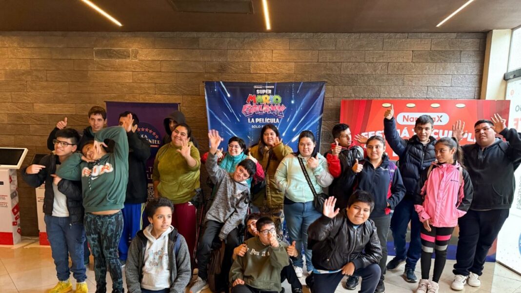 Niños y niñas del Centro Terapéutico de Catamarca disfrutando de una función de cine en una sala.