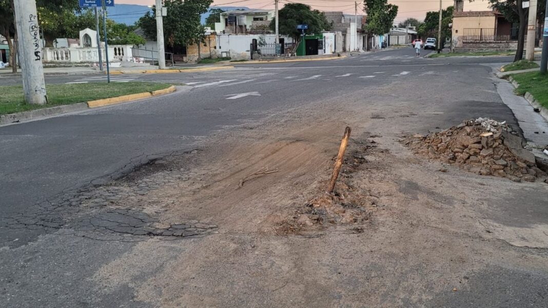 Fotografía referencial de un pozo o socavón en una calle urbana señalizado de manera precaria.