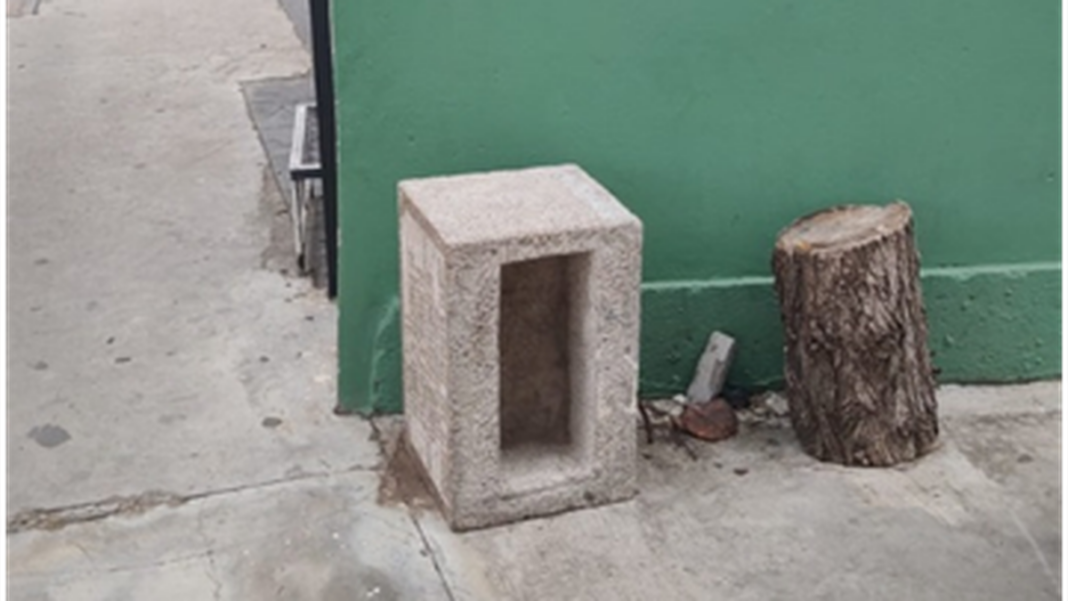 Piedra fundamental de la Junta Nacional del Algodón apoyada contra un muro en el Complejo Cultural Urbano Girardi