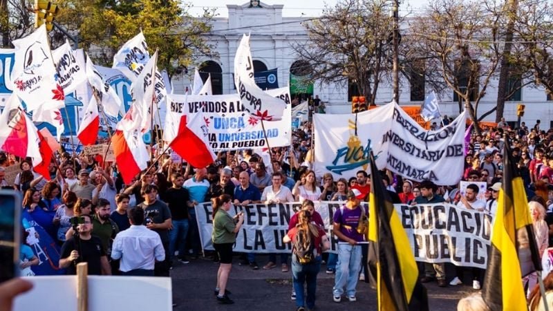 Docentes universitarios en protesta con carteles frente a una universidad