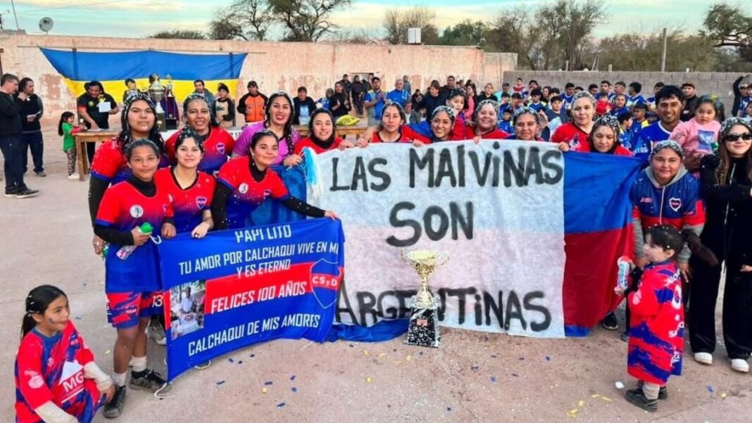 Jugadoras del Club Calchaquí sosteniendo una bandera con la leyenda Las Malvinas son argentinas