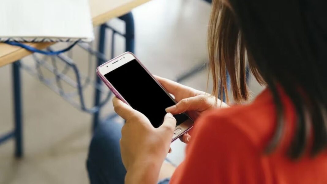 Estudiantes usando celulares en un aula
