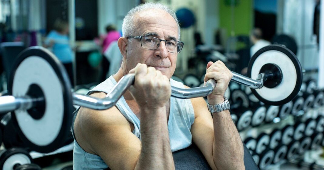 Persona mayor realizando ejercicio de fuerza en un gimnasio