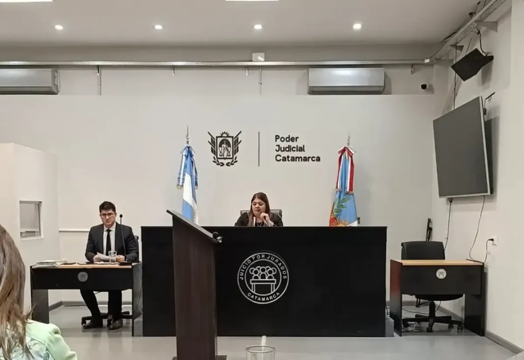 Sala de jurados vacía con documentos sobre la mesa
