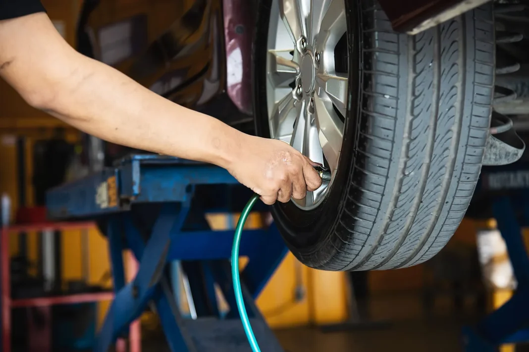 Hombre inflando un neumático de auto en una estación de servicio