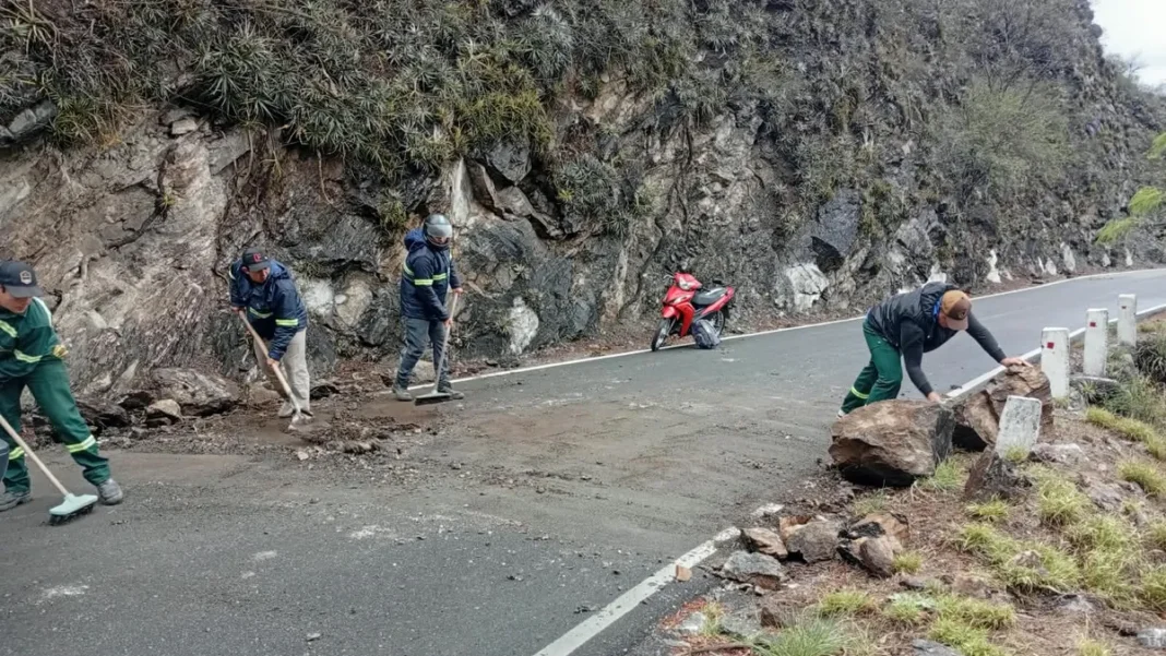 Ruta de montaña con bancos de niebla y equipos de Vialidad trabajando en el despeje de rocas