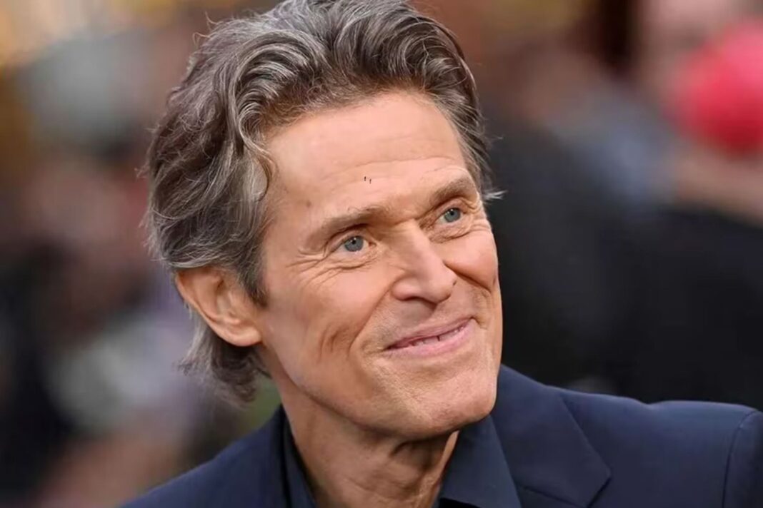 Willem Dafoe sonriendo durante una entrevista
